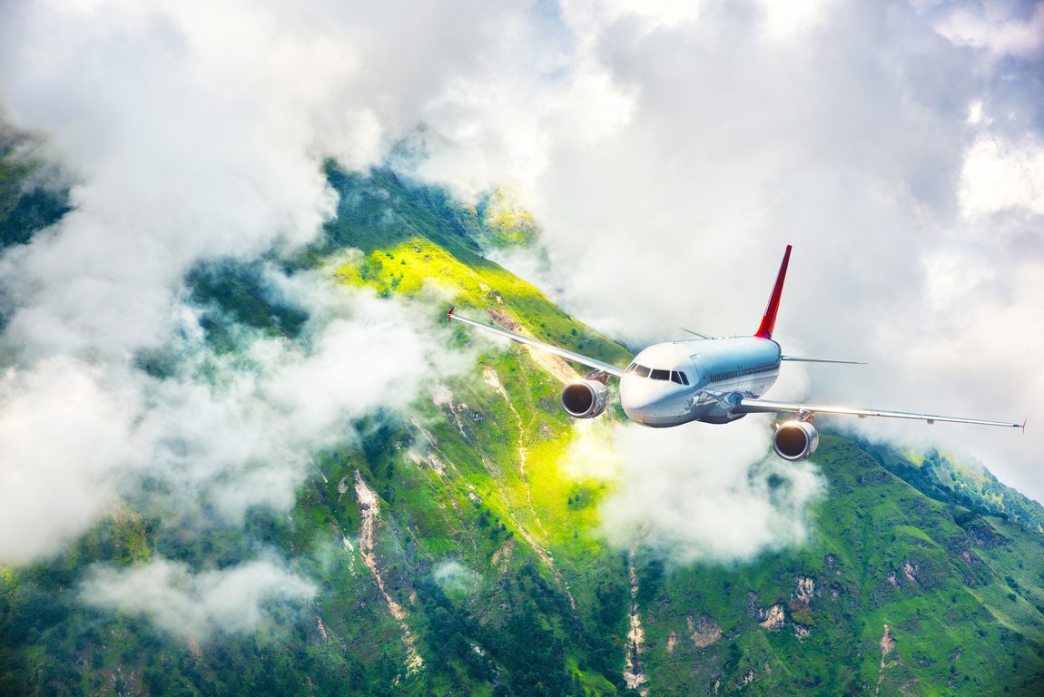 airplane flying over the mountains in clouds